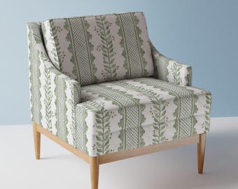 Puede incluir: Un sillón con estampado verde y blanco con marco y patas de madera. El sillón tiene un respaldo alto y un reposabrazos curvo.