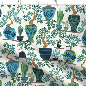 May include: A seamless pattern featuring a repeating design of stylized bonsai trees in blue and green pots with white backgrounds. The trees have brown trunks and green leaves. The pots are decorated with floral patterns.