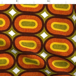 May include: A repeating pattern of overlapping ovals in shades of brown, orange, yellow, and green on a white background.