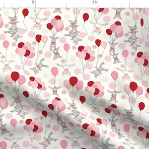 May include: A repeating pattern on a white background features gray bunnies with pink skirts and red or pink balloons. The bunnies appear to be floating. Pink polka dots are scattered throughout the design.