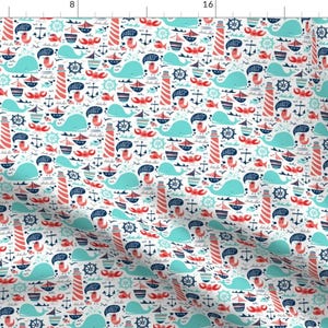 May include: A white fabric with a repeating pattern of blue whales, red lighthouses, red crabs, blue anchors, and blue steering wheels. The background is white.