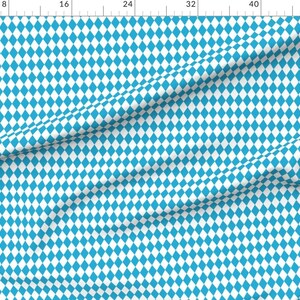 Könnte beinhalten: Ein Stoff mit einem sich wiederholenden Muster aus blauen Rauten auf weißem Hintergrund. Die Rauten sind gleichmäßig angeordnet und erzeugen ein strukturiertes Aussehen. Der Stoff eignet sich für Kleidung oder Heimtextilien.