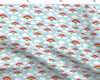 Peut inclure: Un motif répété d'arcs-en-ciel colorés sur un fond bleu clair. Chaque arc-en-ciel est composé de rouge, orange, jaune, vert, bleu, indigo et violet. Les arcs-en-ciel sont entourés de nuages blancs et de petits points roses, bleus et verts.
