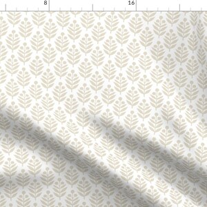 May include: A white fabric with a repeating pattern of beige stylised leaves. The leaves are arranged in a diamond pattern.