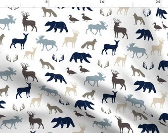 May include: A white background with a repeating pattern of blue, brown, and tan woodland animals. The animals include deer, moose, bears, foxes, and ducks. There are also antlers in the pattern.