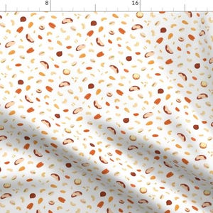 Puede incluir: Un fondo blanco con un patrón repetitivo de varios frutos secos, incluyendo anacardos, almendras y nueces de Brasil. Las nueces son en tonos de marrón, beige y naranja.