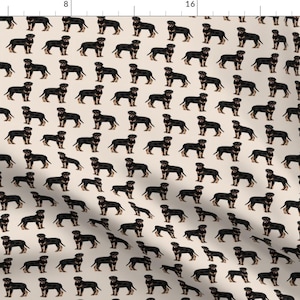 Puede incluir: Un patrón sin costuras con perros negros y tostados sobre un fondo beige. Los perros están todos mirando hacia adelante y tienen las colas enroscadas. El patrón se repite en toda la tela.