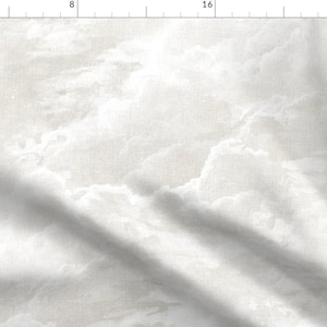 May include: A white and light gray fabric featuring a repeating cloud pattern. The textile displays soft, ethereal shapes in varying shades of off-white and pale gray, creating a subtle, atmospheric design across the entire surface of the material.
