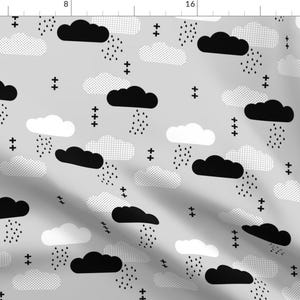 May include: A gray fabric with a black and white geometric pattern of clouds and raindrops. The pattern is repeated throughout the fabric.