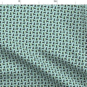 May include: A repeating pattern of black dog silhouettes on a light blue background with a subtle green and blue speckled pattern.