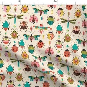 May include: A fabric pattern featuring a repeating design of various insects including beetles, dragonflies, and moths in shades of teal, orange, pink, yellow, and brown on a cream background, with a ruler visible along the top and left edges.
