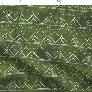 May include: Green fabric with a white geometric pattern of triangles and dots. The pattern is reminiscent of mountain peaks.