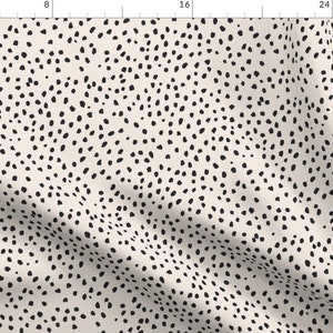 Puede incluir: Un patr&oacute;n sin costuras con un fondo beige y un dise&ntilde;o de lunares negros dispersos. Los lunares son irregulares en forma y tama&ntilde;o, creando una est&eacute;tica l&uacute;dica y moderna.