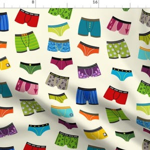 Pode incluir: Um fundo cor de creme com um padrão repetitivo de roupa interior colorida. A roupa interior é de vários estilos e cores, incluindo vermelho, azul, verde, amarelo, roxo e laranja. Algumas das peças de roupa interior têm um estampado gráfico, enquanto outras são de cores sólidas.