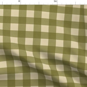May include: Olive green and cream-colored gingham fabric. The pattern features a classic check design, with alternating squares of olive green and cream. The fabric is likely cotton or a similar material, suitable for various sewing projects.