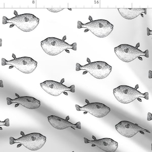 May include: A repeating pattern of black and white pufferfish illustrations on a white background. The fish are drawn in a detailed, realistic style, with visible scales and fins. The design is suitable for fabric or wallpaper.