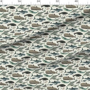May include: A seamless pattern featuring a variety of watercolor illustrations of whales, dolphins, and other sea creatures in shades of blue, gray, and white on a cream background.