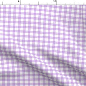 May include: A white and light purple gingham fabric with a subtle diagonal pattern. The fabric is soft and lightweight, making it ideal for a variety of sewing projects.