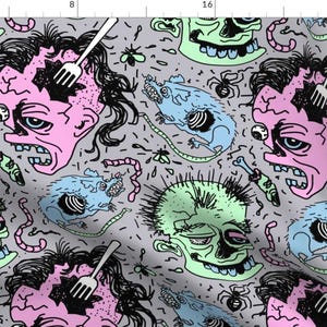 May include: A repeating pattern of cartoon faces with pink, green, and blue skin tones. The faces have black eyes and mouths, and some have forks sticking out of their heads. The background is a light gray with black lines and shapes.