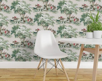 May include: Wallpaper featuring a repeating pattern of a hunting scene with riders on horseback, dogs, and trees. The color palette includes shades of green, brown, red, and beige. The wallpaper is displayed behind a white chair and table with plants.
