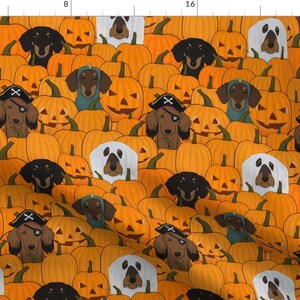 May include: A repeating pattern of orange pumpkins with carved faces and various dog breeds. Some dogs wear pirate hats or costumes. The design is suitable for Halloween-themed products.