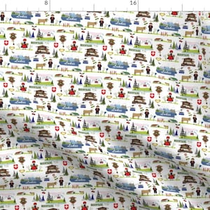 Può includere: Un tessuto bianco con un motivo ripetuto di illustrazioni a tema svizzero. Il motivo include immagini di montagne, laghi, mucche, orologi a cucù e bandiere svizzere. Il testo "Alpi" e "Laghi" appare nel motivo.