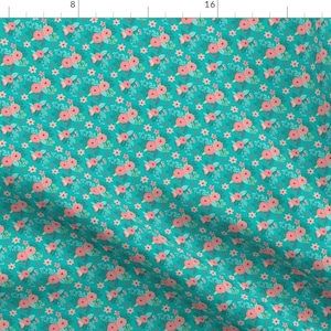 May include: A teal fabric with a repeating pattern of pink flowers and small white flowers. The fabric has a subtle texture.