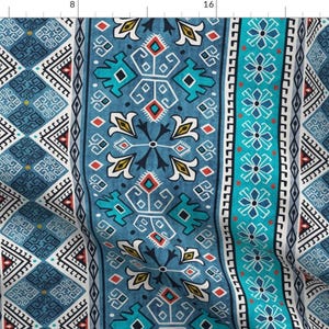 May include: A teal, blue and white fabric with a geometric pattern. The pattern is made up of repeating squares, diamonds and triangles. The fabric is ideal for quilting, sewing or crafting.