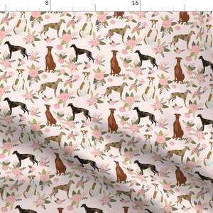 May include: A pink fabric with a repeating pattern of greyhounds and pink flowers. The greyhounds are in various poses, including running, sitting, and standing. The flowers are in a variety of shapes and sizes.