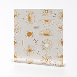 May include: A beige fabric with a repeating pattern of gold sunbursts and geometric shapes. The sunbursts are stylized with radiating lines and a half-circle shape.