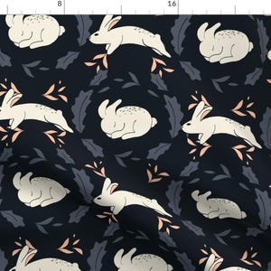 May include: A seamless pattern featuring white rabbits hopping and resting on a dark blue background. The rabbits are surrounded by pink and gray floral elements.