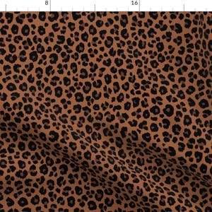 May include: A brown fabric with a black leopard print pattern.