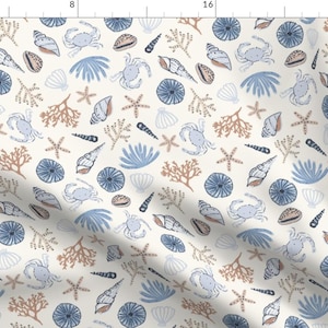 Könnte beinhalten: Cremefarbener Stoff mit einem sich wiederholenden Muster aus Meeresmotiven. Das Design umfasst blaue Krabben, Muscheln, Seesterne und Korallen in Blau-, Braun- und Cremetönen. Geeignet für verschiedene Bastelprojekte.