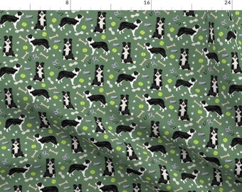 May include: A green fabric with a repeating pattern of black and white border collies, bones, tennis balls, and dog leashes.