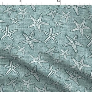 Könnte beinhalten: Ein Stoffmuster mit einem sich wiederholenden Design aus weißen Seesternen auf einem strukturierten, teal-farbenen Hintergrund. Die Seesterne variieren in der Größe und sind mit kleinen Punkten detailliert, was ein maritimes Thema schafft. Die Textur des Stoffes erhöht das visuelle Interesse.
