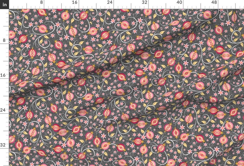May include: A seamless pattern featuring pink pomegranates with yellow seeds on a dark gray background. The pomegranates are surrounded by delicate white and light blue floral vines.