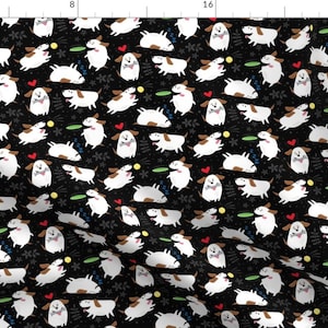 May include: A black fabric with a repeating pattern of white dogs playing with frisbees and bones. The dogs are drawn in a simple, cartoon style.