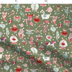 May include: A green fabric with a repeating pattern of Christmas-themed illustrations. The pattern includes ballerinas, swans, candy canes, stars, and other festive elements.