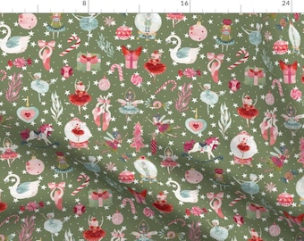 May include: A green fabric with a repeating pattern of Christmas-themed illustrations. The pattern includes ballerinas, swans, candy canes, stars, and other festive elements.