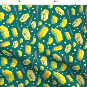 May include: Teal fabric with a repeating pattern of yellow butter sticks, melted butter, and butter knives. The text "BUTTER" is printed on the sticks.