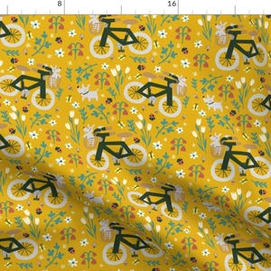 May include: A seamless pattern featuring a repeating design of bicycles with baskets, small white dogs, and flowers on a yellow background.