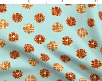 May include: A seamless pattern featuring brown and tan waffles on a light blue background. The waffles are arranged in a repeating pattern, with some waffles having a pat of butter on top.