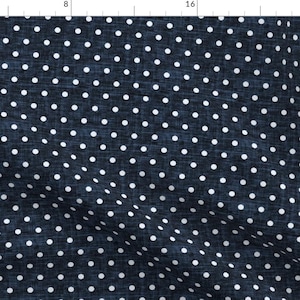 May include: A dark blue fabric with a white polka dot pattern. The fabric has a textured, denim-like appearance.
