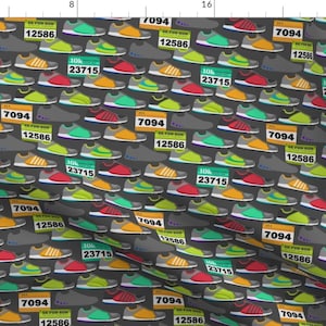 May include: A repeating pattern of colorful running shoes with race bibs on a dark gray background. The bibs have numbers like 7094, 12586, and 23715.