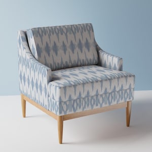 Könnte beinhalten: Ein blauer und weißer Sessel mit Holzbeinen. Der Sessel hat eine geschwungene Rückenlehne und einen bequemen Sitz.