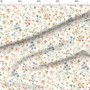 May include: Fabric with a delicate floral pattern. The design features a cream-colored background with an all-over print of small wildflowers in shades of pink, blue, yellow, and green. The fabric is likely suitable for various sewing projects.