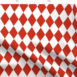 May include: A red and white harlequin pattern with a diamond shape. The fabric is folded and has a slight wrinkle.