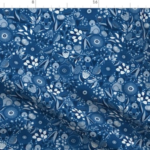 May include: A blue fabric with a white repeating pattern of koalas, flowers, and leaves. The pattern is a whimsical and charming design.