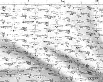 以下が含まれることがあります： 白い背景に、黒い線で描かれた複葉機の繰り返しパターンがあります。複葉機はすべて同じ方向を向いており、ずらしたパターンで配置されています。