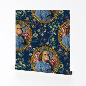 May include: A repeating pattern wallpaper featuring a portrait of a man in a blue jacket blowing a bubble. The portrait is framed in gold and set against a blue background with floral and leaf designs.